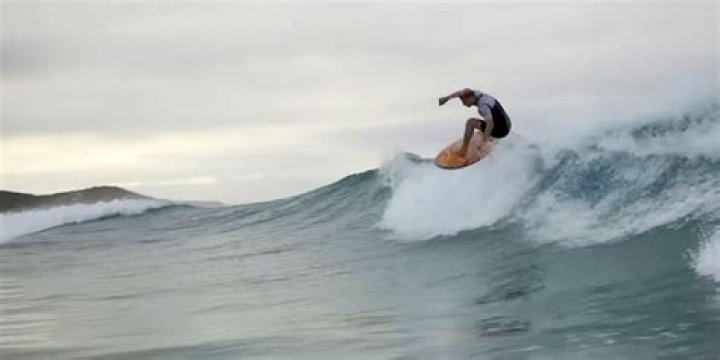 A still of someone surfing in Surviving Summer season 2 on Netflix.