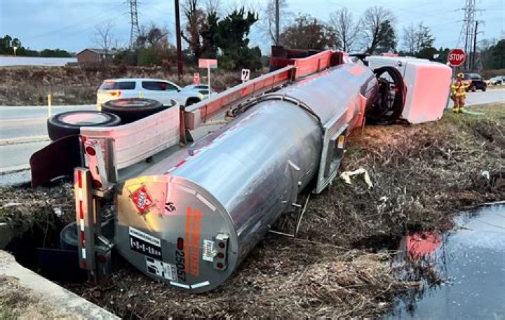 A truck overturned, spilling its items, and a group of women laughing together A truck overturned, spilling its items, and a group of women laughing together