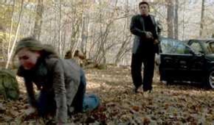 Adriana on her knees in a forest while Silvio attempts to shoot her in The Sopranos