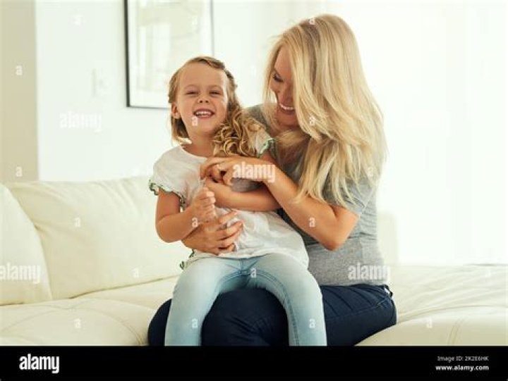 Little girl, sitting on her bed, knocks mum, dad
