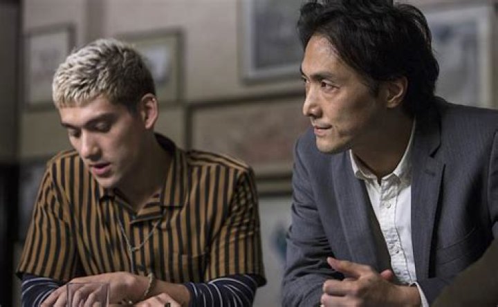 Takehiro Hira as Kenzo Mori sitting inside a restaurant in Giri Haji