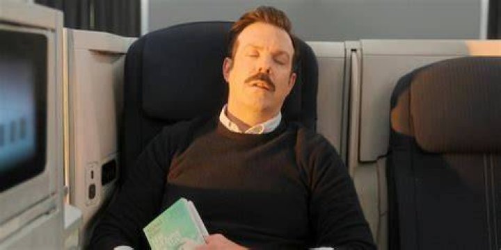 Ted Lasso (Jason Sudeikis) sleeping on a plane in the Ted Lasso season 3 finale
